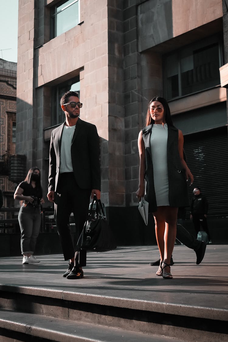 Businessman And Woman Walking Near Building