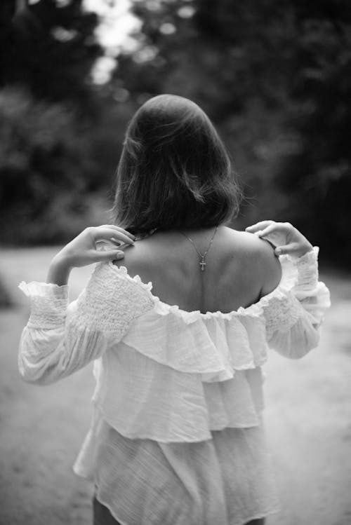 Grayscale Photo of a Woman in White Long Sleeve Shirt