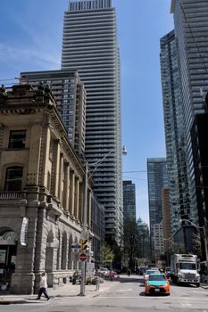 Vibrant street view of Toronto's towering skyscrapers on a sunny day.