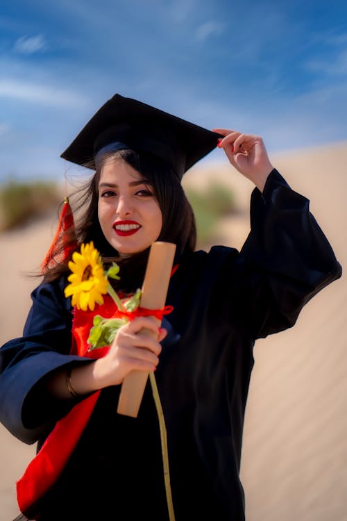 Woman in Academic Dress Holding a Sunflower 