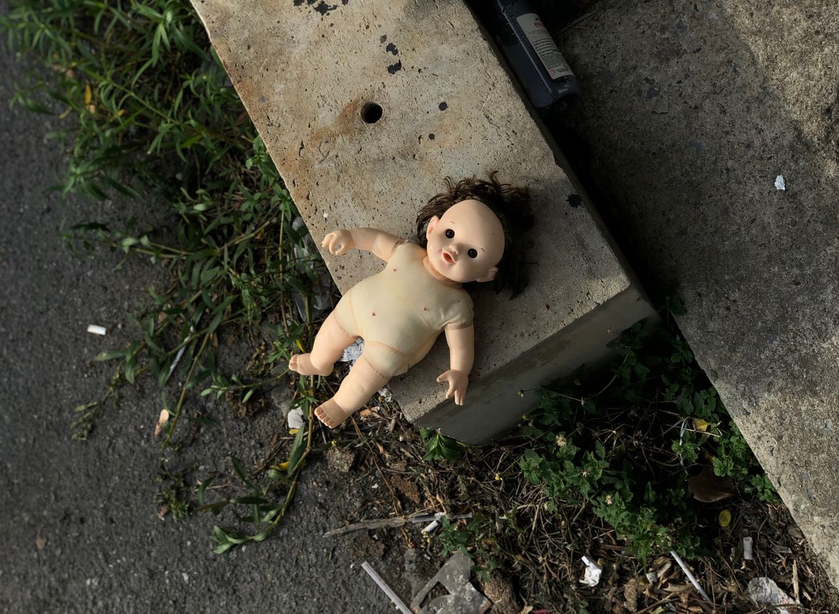 Baby doll lying on a textured outdoor surface