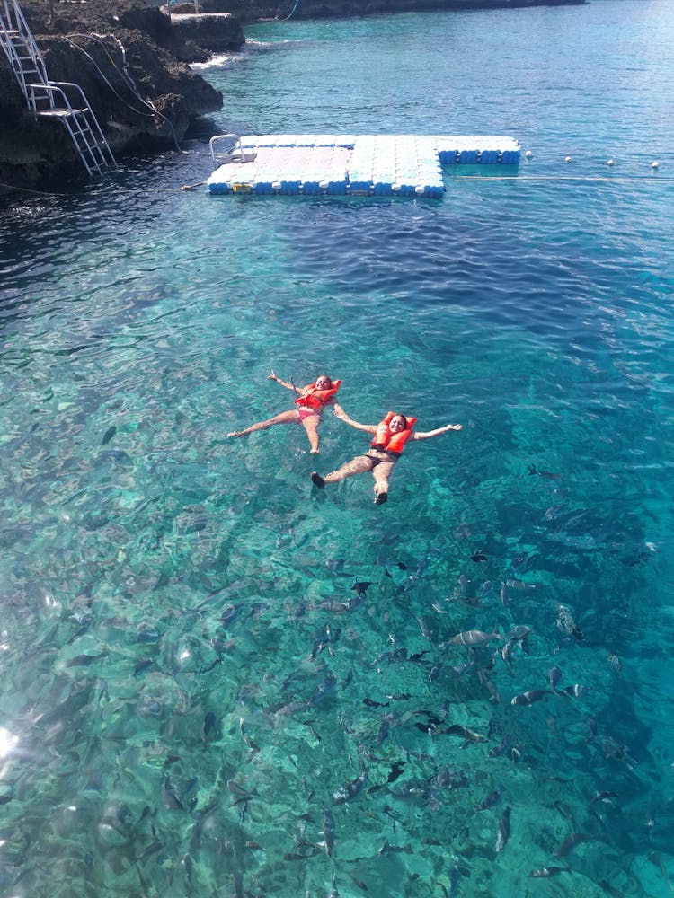 Women Swimming While Wearing Life Vests