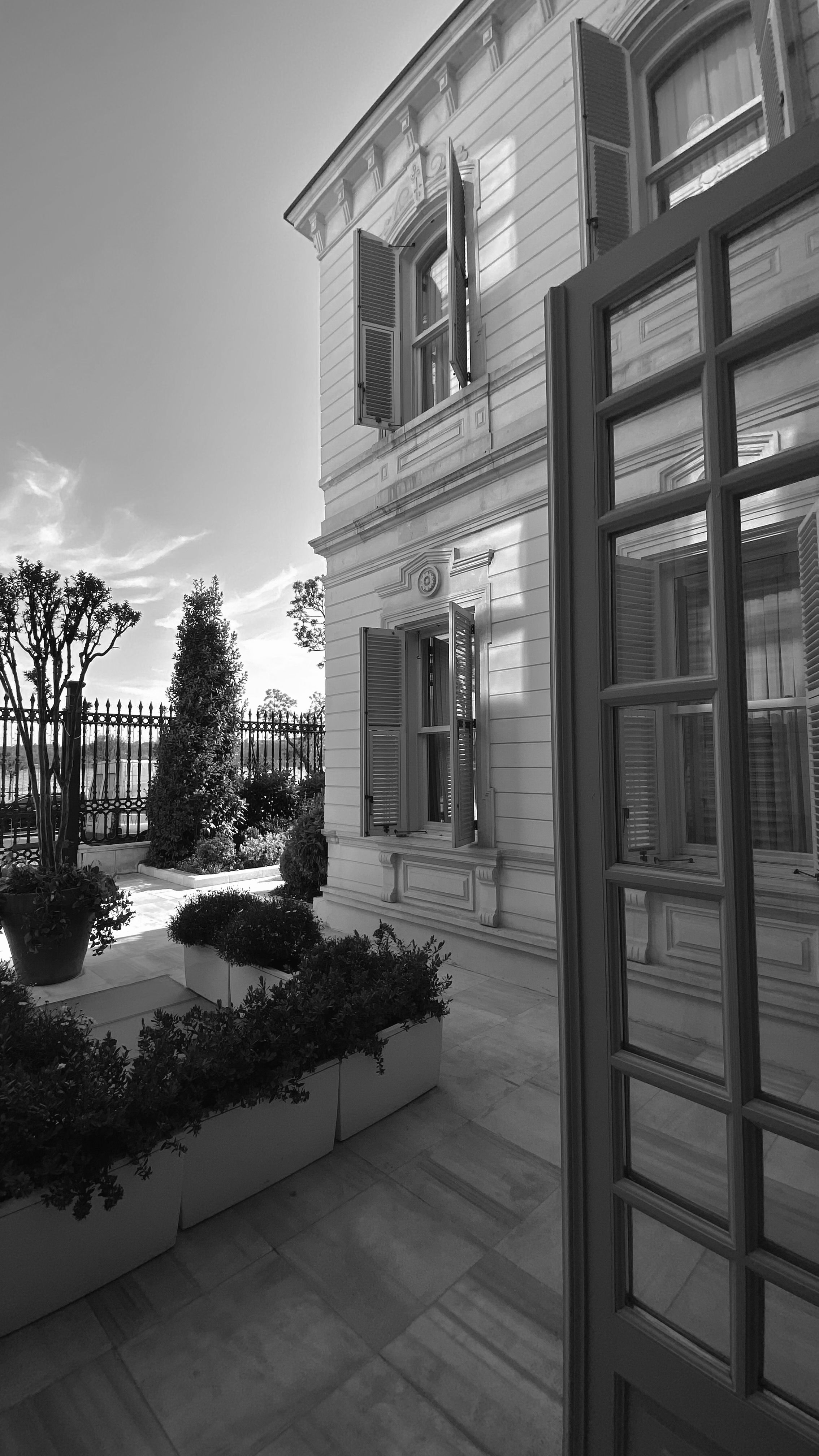 A detailed black-and-white exterior view of a classic residential building, showcasing elegant architectural design.
