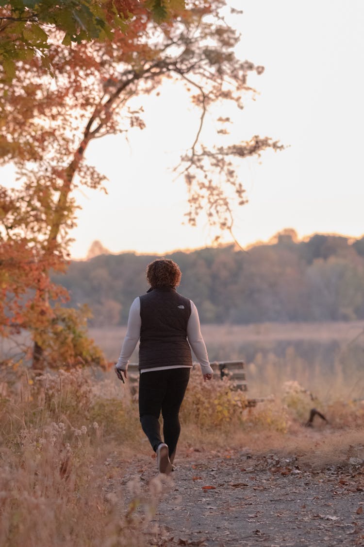 Backview Of Person Walking On Dirt Road 