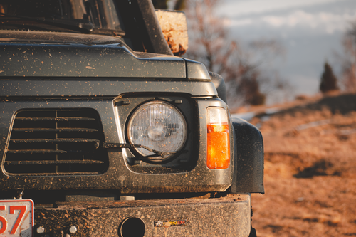 Free A detailed view of a dirty off-road vehicle's headlight captured in an outdoor setting. Stock Photo