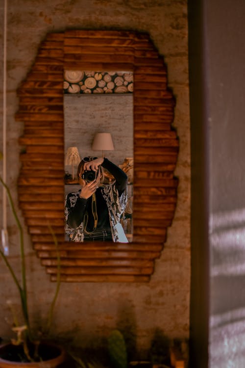 Woman Taking a Photo of a Wooden Framed Wall Mirror