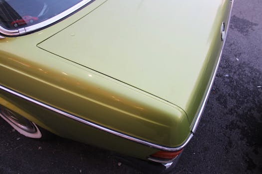 A detailed view of a vintage green car trunk, showcasing a classic design.