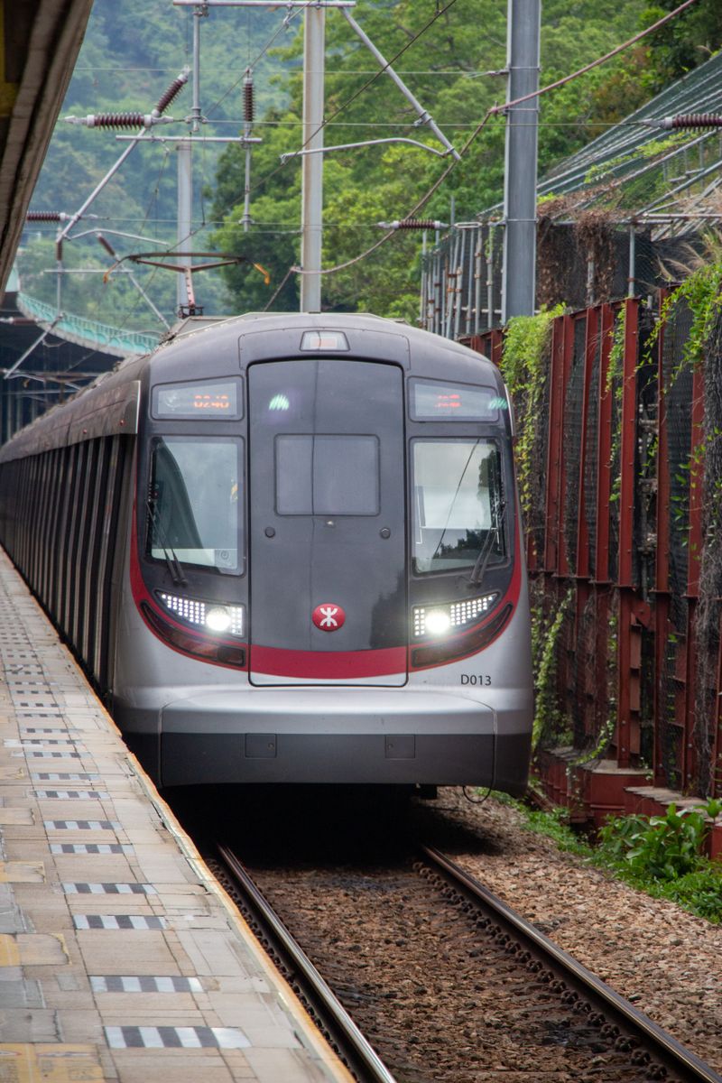 A modern train arrives at a station in Hong Kong, showcasing urban public transportation.