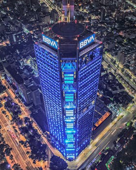Stunning aerial view of the illuminated Torre BBVA in Mexico City at night.