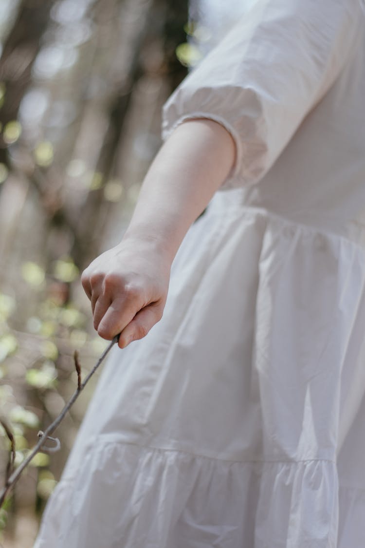 Girl In White Dress Holding A Stick