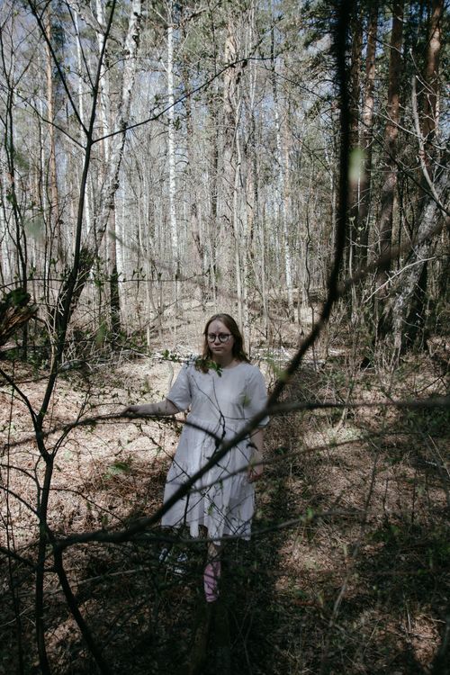 Free A woman in a white dress strolls through a peaceful autumn forest, surrounded by tall trees. Stock Photo
