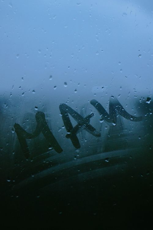Free Raindrops on a fogged window with handwritten letters creating a moody atmosphere. Stock Photo