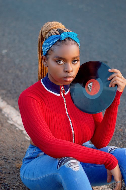 A Young Woman Sitting Holding a Vinyl Record