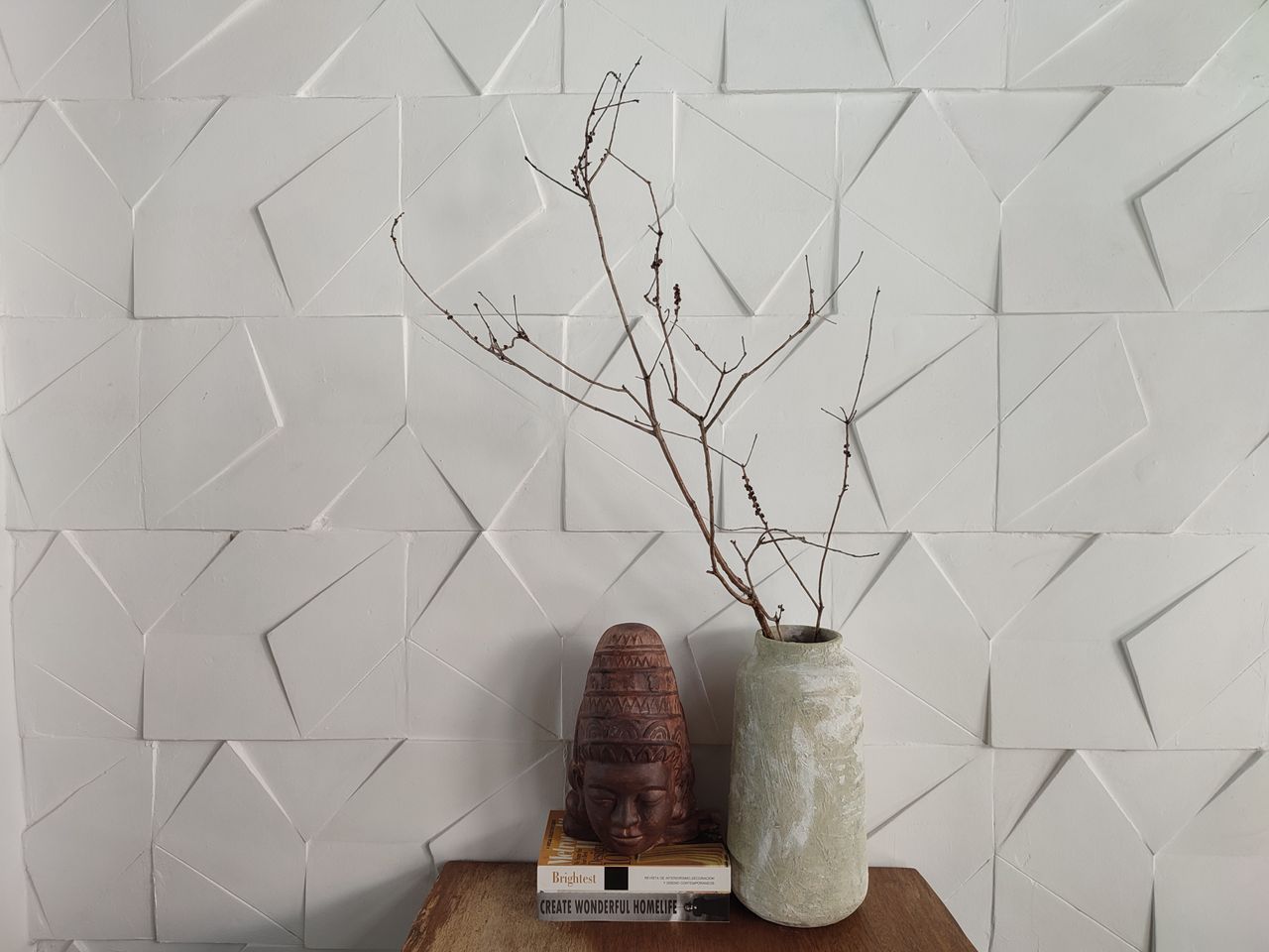 minimalist decor featuring a textured vase and tribal figurine against