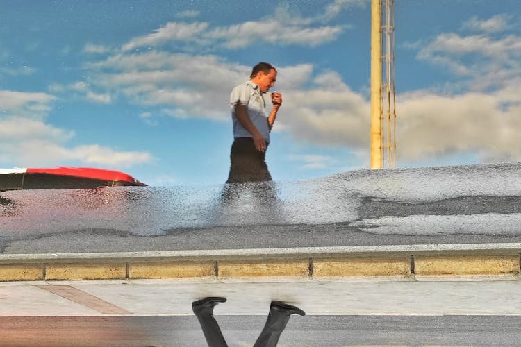 Officer With Cup Reflecting In Puddle