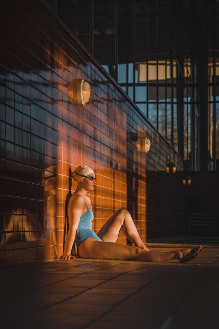 Woman Swimmer Sitting On Floor By Pool