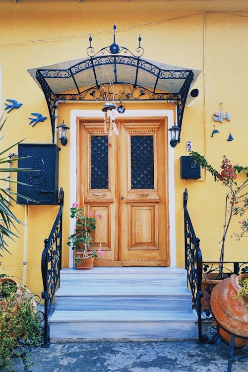 Brown Wooden Double Doors on Yellow Concrete Wall