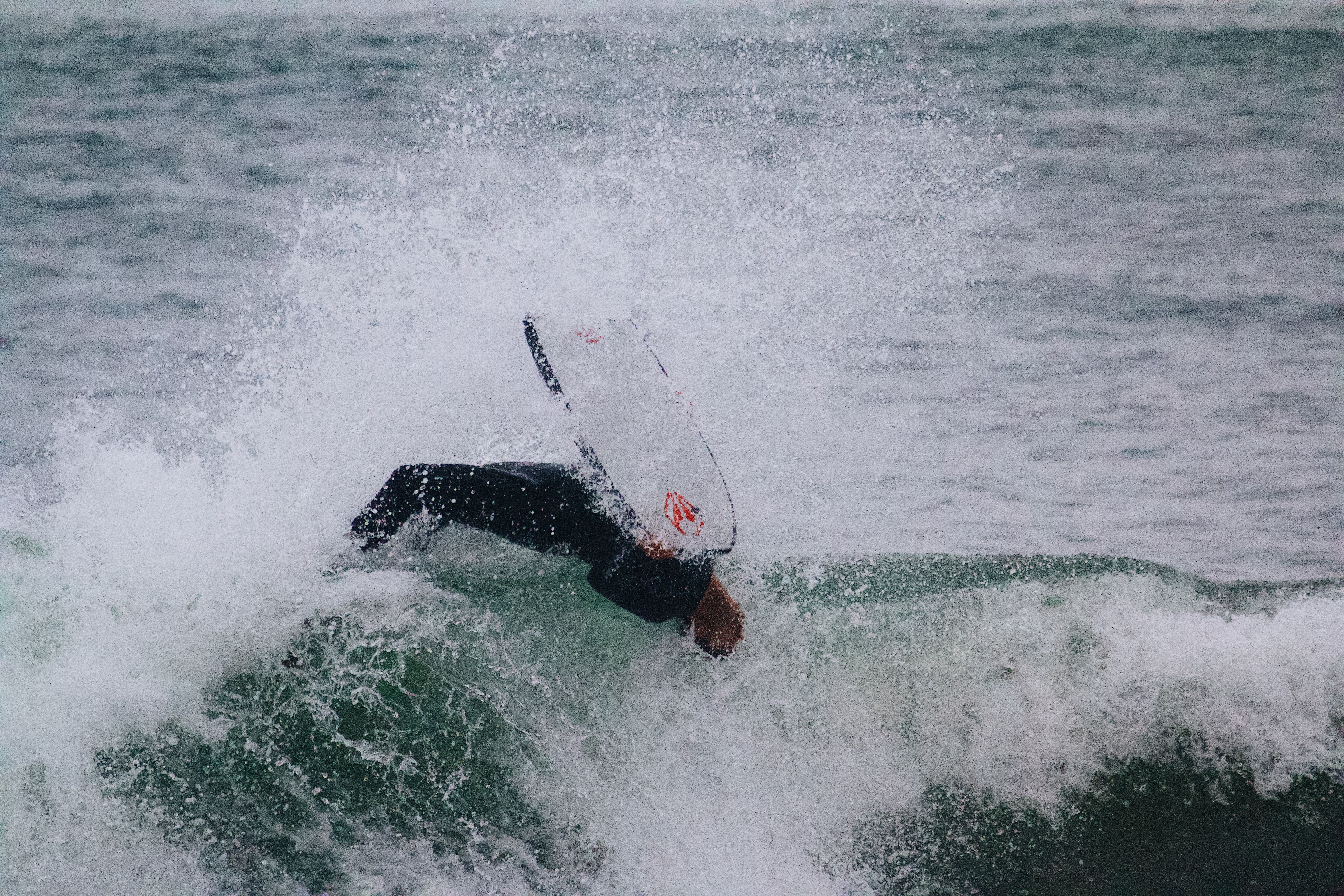 Surfer performing acrobatics in ocean waves at PV, Spain. Vibrant and energetic shot.