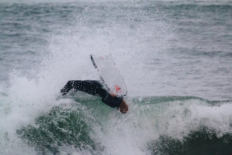 Man In Black Wetsuit Surfing On Ocean Waves