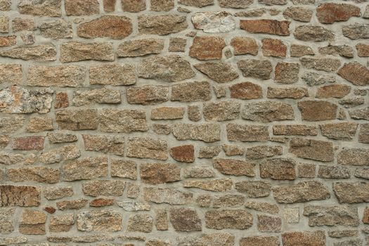 Close-up of a rough stone wall texture in a vertical orientation, ideal for backgrounds.