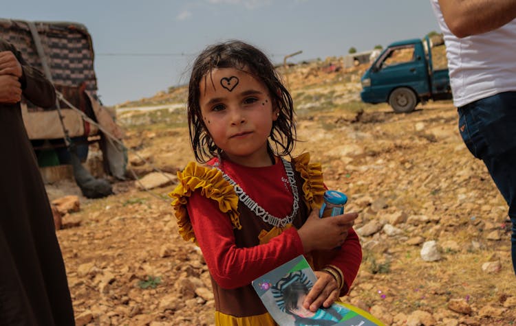 Poor Girl Child In Desert Landscape