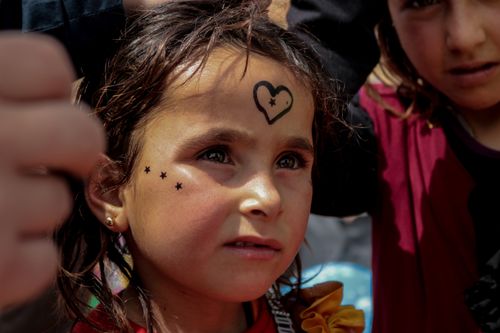 Free Heartwarming portrait of a girl with face paint in Idlib, Syria, capturing her thoughtful expression. Stock Photo
