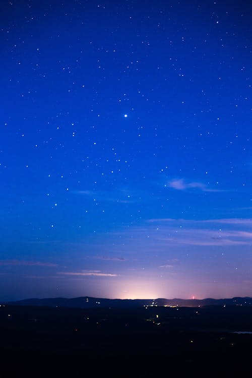 Silhouette of Mountain Range Under Stars