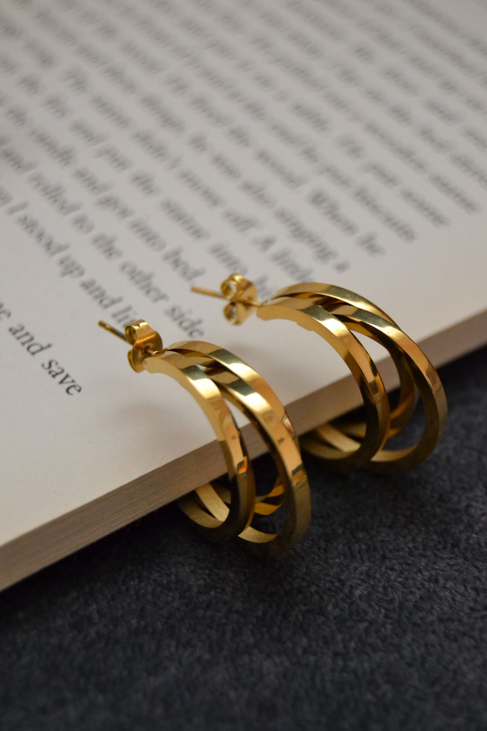 Gold earrings resting on open book pages