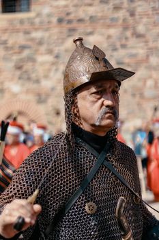 Portrait of a medieval knight in armor during a historical reenactment outdoors.