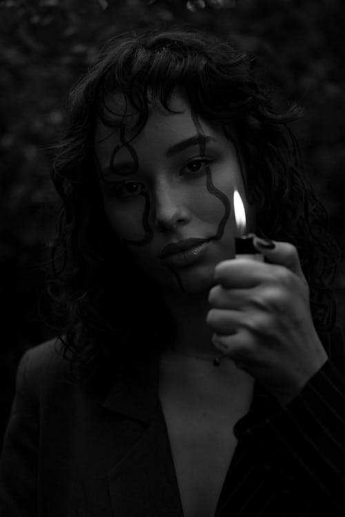 Grayscale Photo of Woman Holding a Lighter