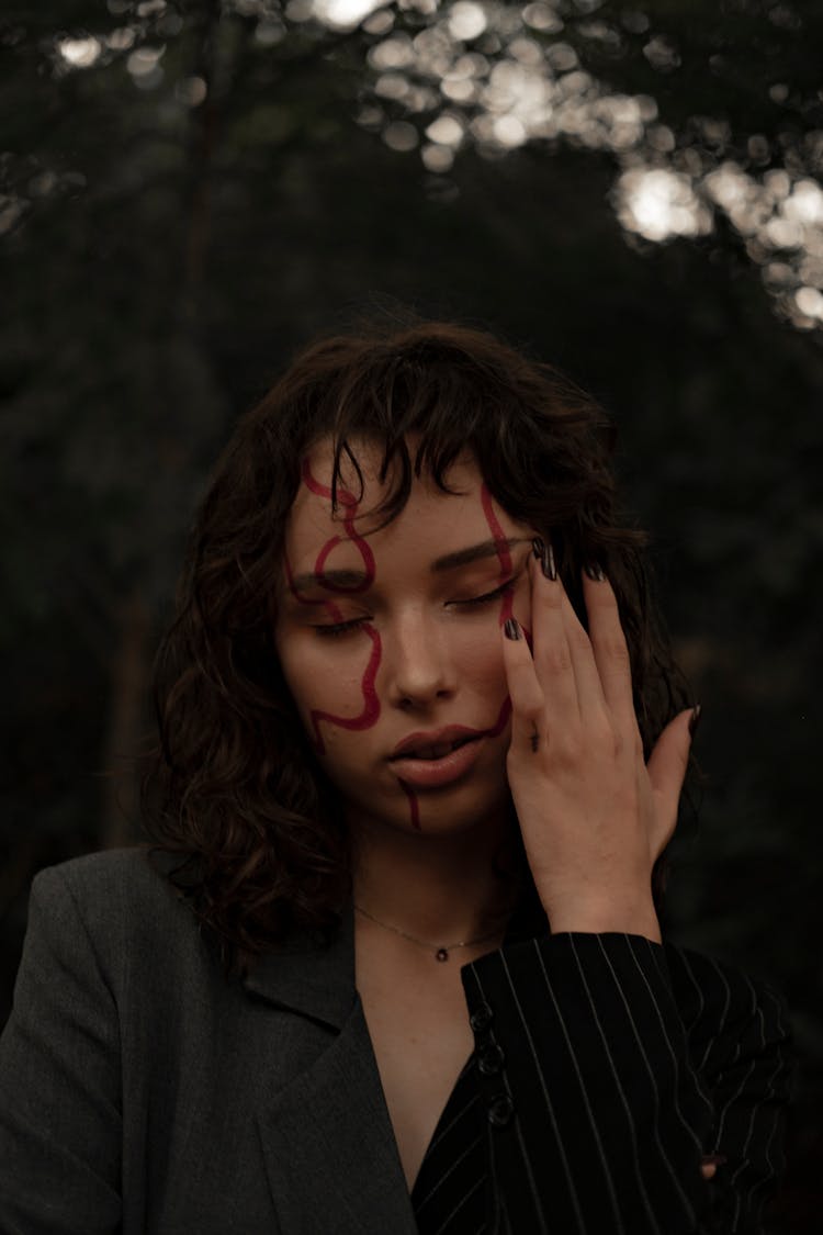 Woman With Drawing On Face In Nature