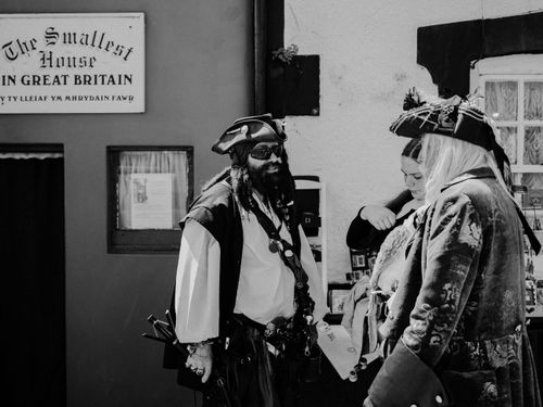 Free Three people in pirate costumes at the Smallest House in Great Britain. Stock Photo