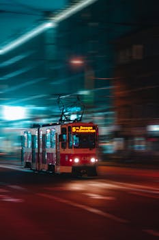 Blurred tram speeding through Kaliningrad streets at night, capturing urban motion and vibrant city lights.
