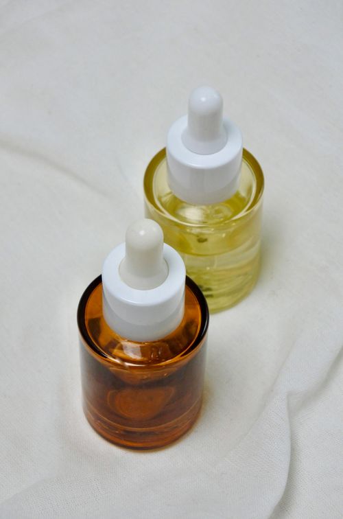 Free Close-up view of elegant brown and yellow glass bottles with droppers, ideal for skincare products. Stock Photo