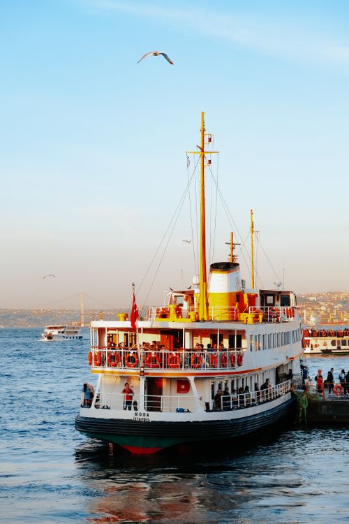 Free A scenic ferry docked at a bustling waterfront pier, showcasing lively transportation and urban views. Stock Photo