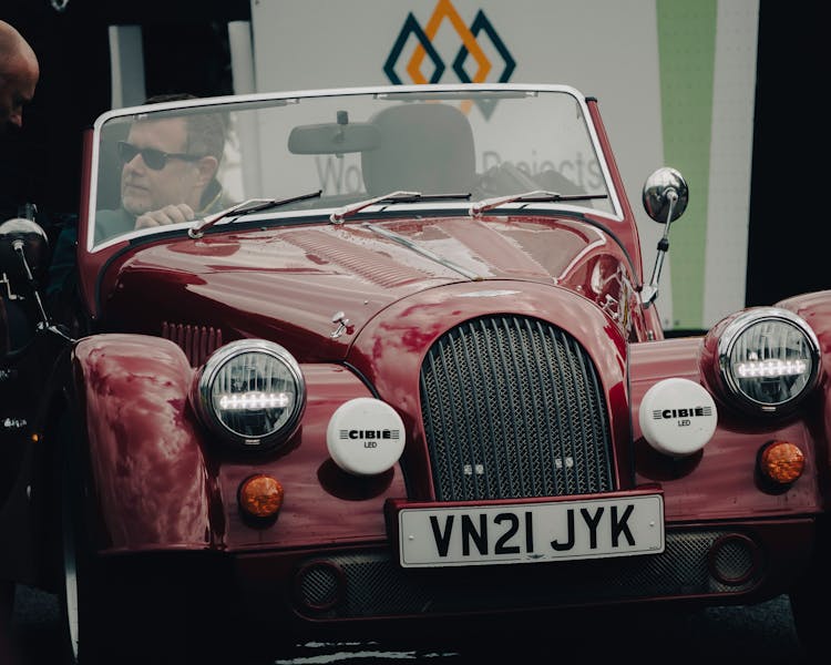 Man Driving A Red Classic Car