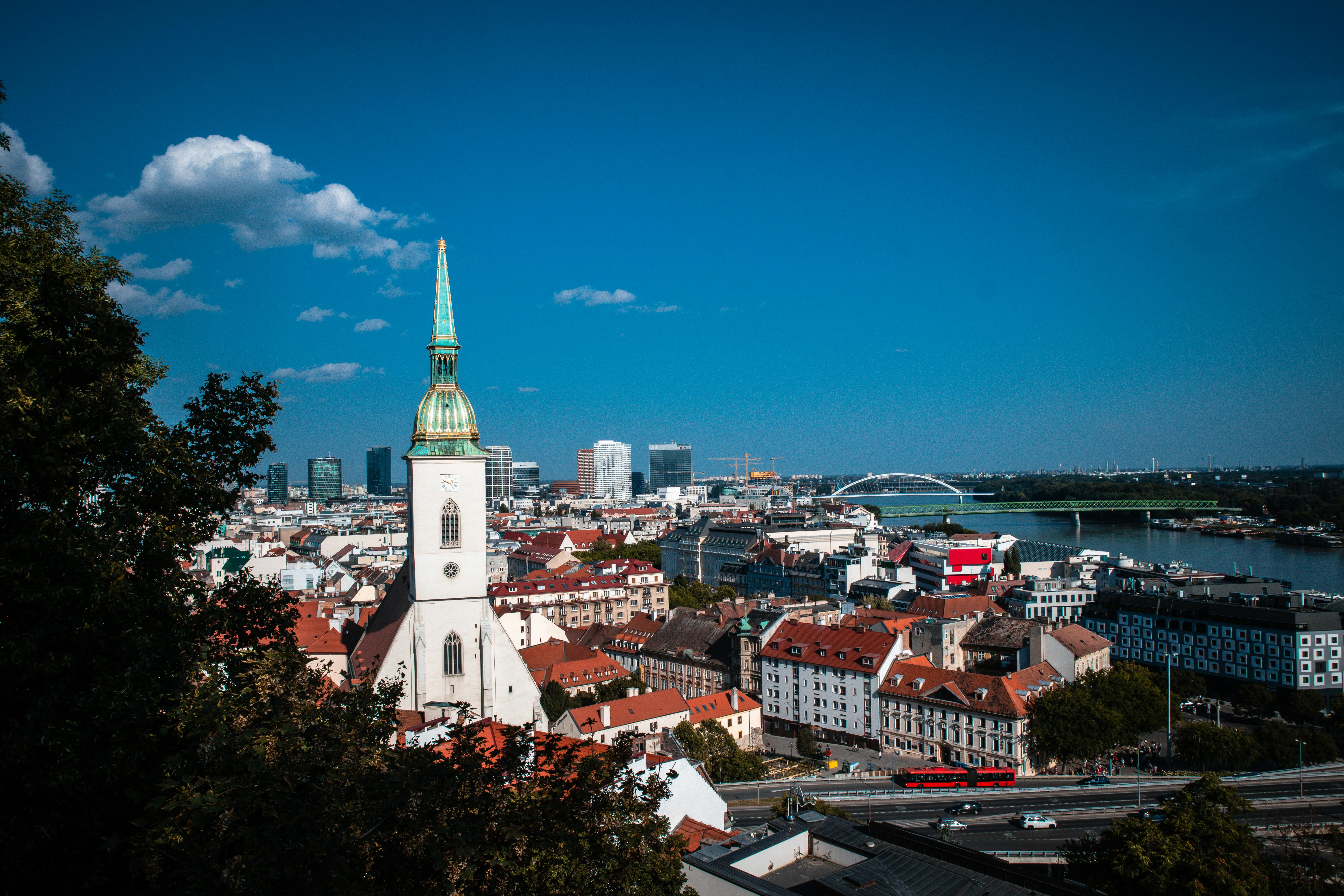 Stunning view of St. Martin's Cathedral with Bratislava skyline and Danube River under a clear blue sky.
