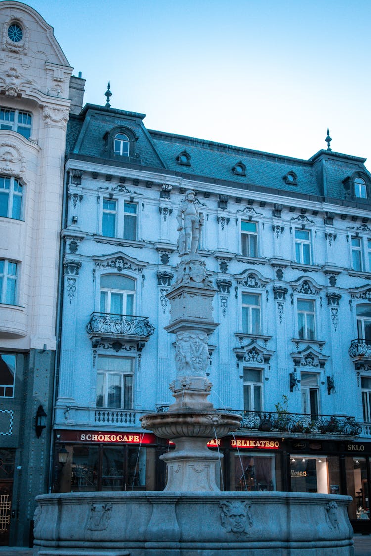 The Roland Fountain In Front Of The Concrete Building