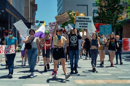 Women leading a vibrant protest for empowerment and social justice in an urban setting.
