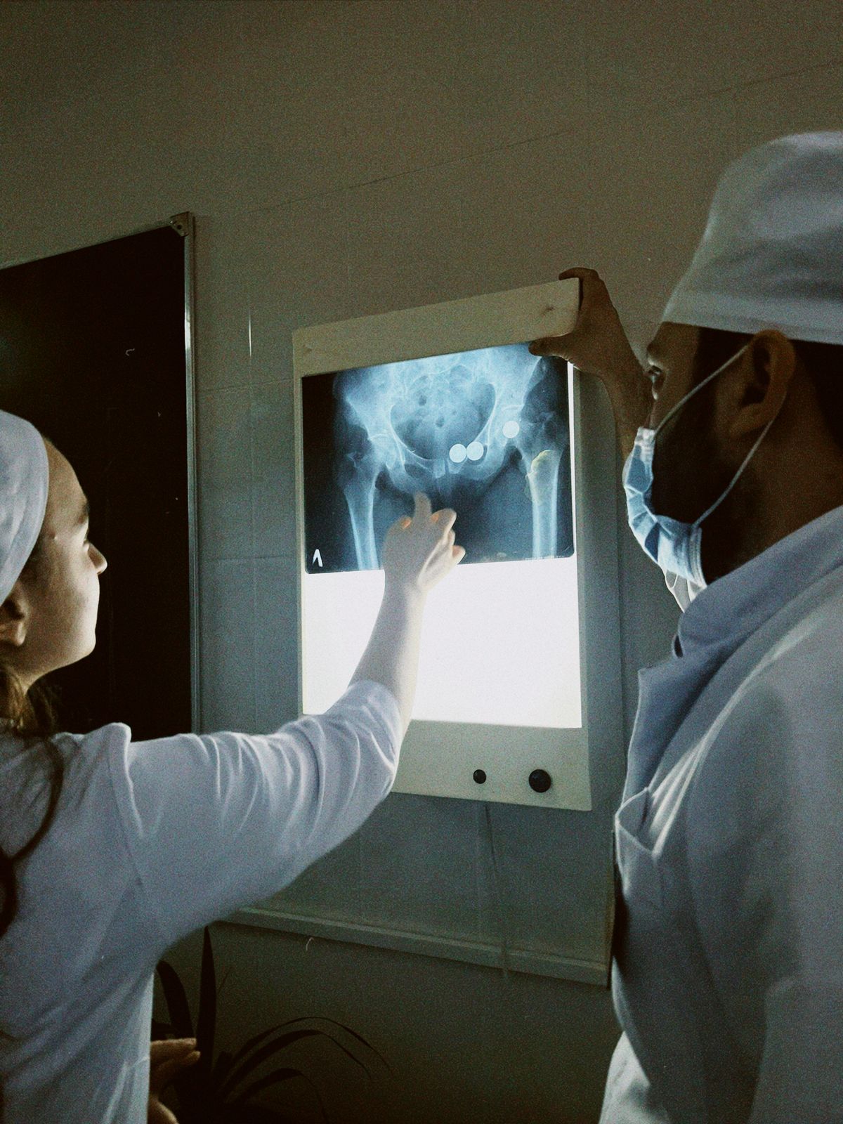 Two clinicians reviewing an X-ray together while coordinating a patient's care.