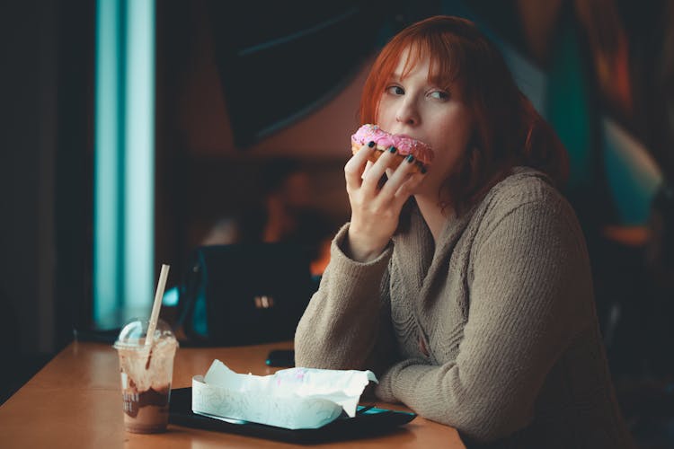 Woman In Gray Sweater Eating Doughnut 