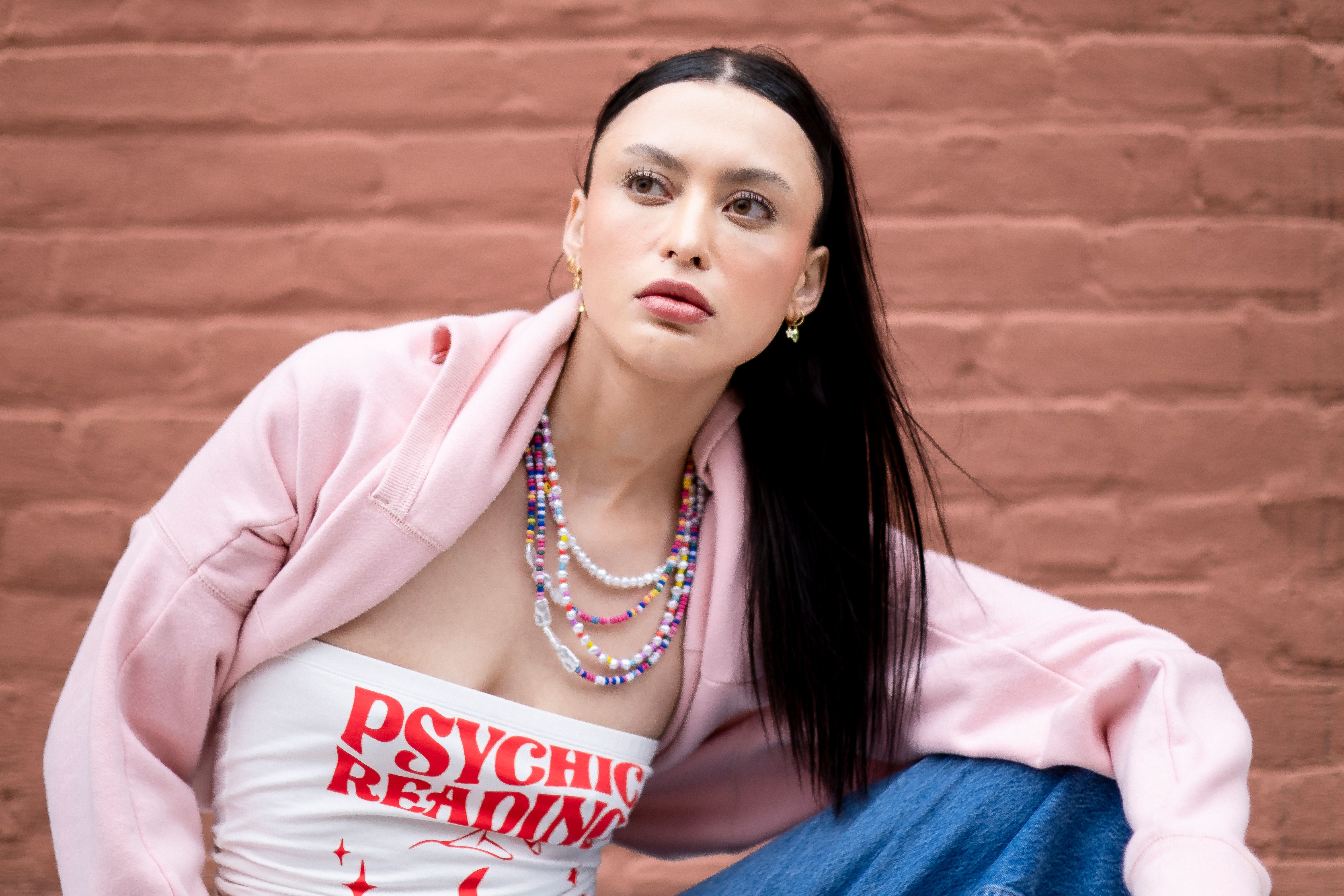 A woman wearing three layered necklaces of varying lengths and textures