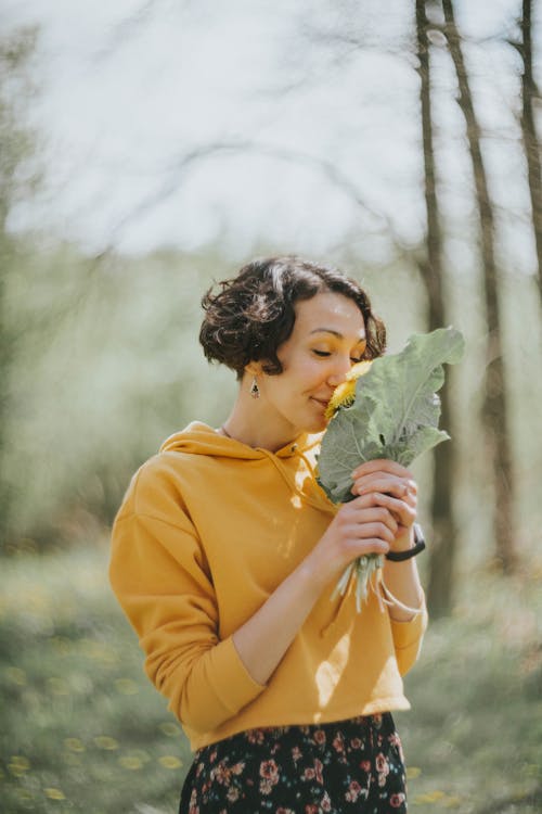 Free Woman in Yellow Polo Shirt Holding Green Leaf Stock Photo