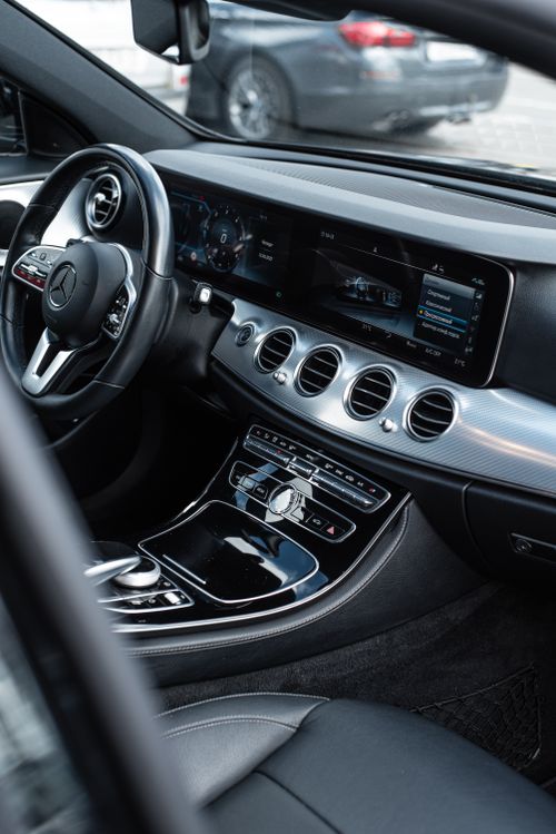 Free Sleek interior view of a luxury car with a modern, high-tech dashboard and steering wheel. Stock Photo