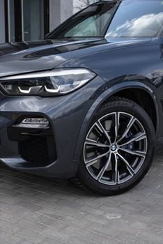 Elegant black car parked outdoors showcasing its sleek alloy wheels and modern design.