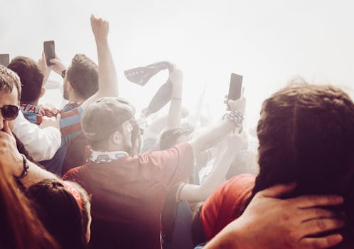 Lively crowd cheering and capturing moments at a sports event with energy and excitement.