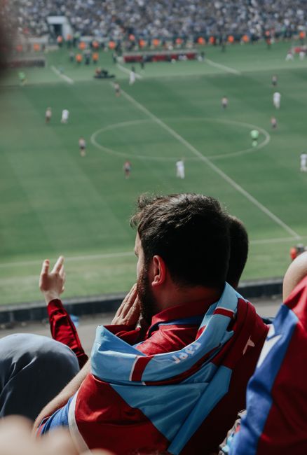 Close-up of a family gathered around their TV watching the World Cup match