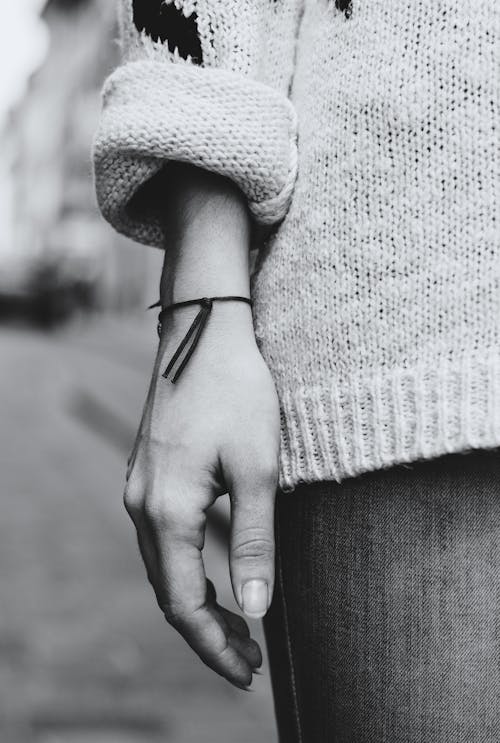 A Grayscale of a Person Wearing a Bracelet