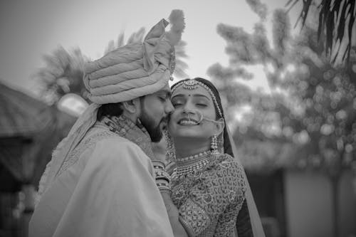 A Grayscale of a Couple in Their Traditional Wedding Clothing