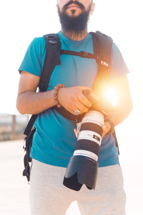 Man Holding Black And White Dslr Camera